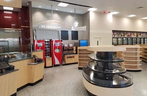 Gas station interior featuring a beverage station with "ICE COLD DRINKS" signage, vending machines, and shelving, illustrating commercial renovation capabilities by OZ General Contracting.