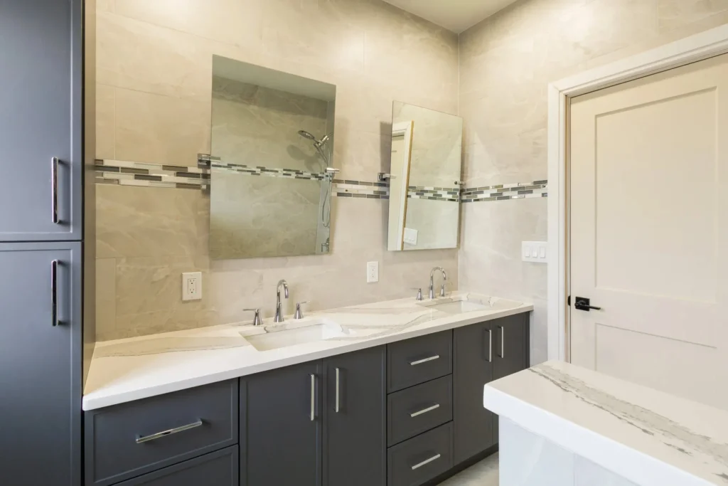 Modern bathroom with double sinks, large mirrors, and elegant tile accents.