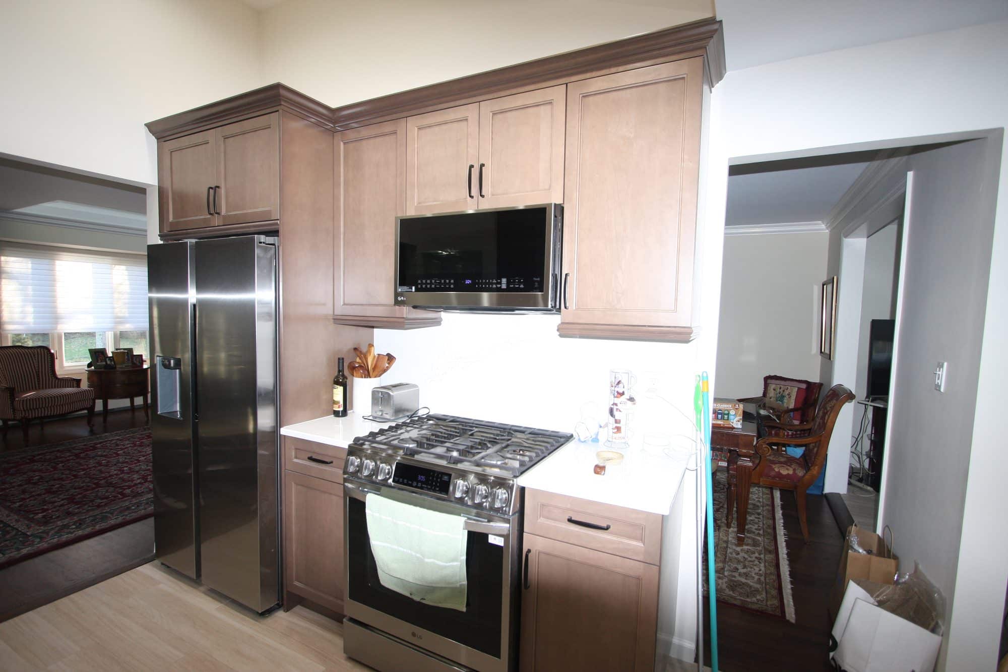 Range wall with stacked upper cabinets, over-range microwave and white quartz counters on both sides of the range